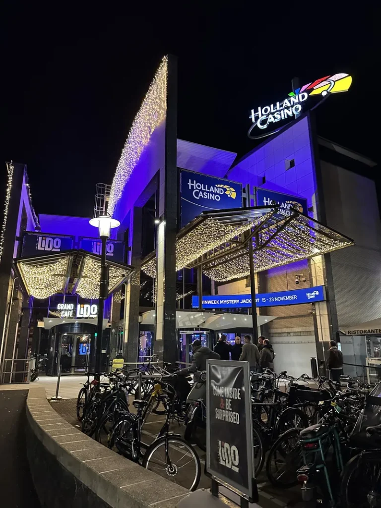 Verlichte ingang van Holland Casino Amsterdam Centrum bij nacht