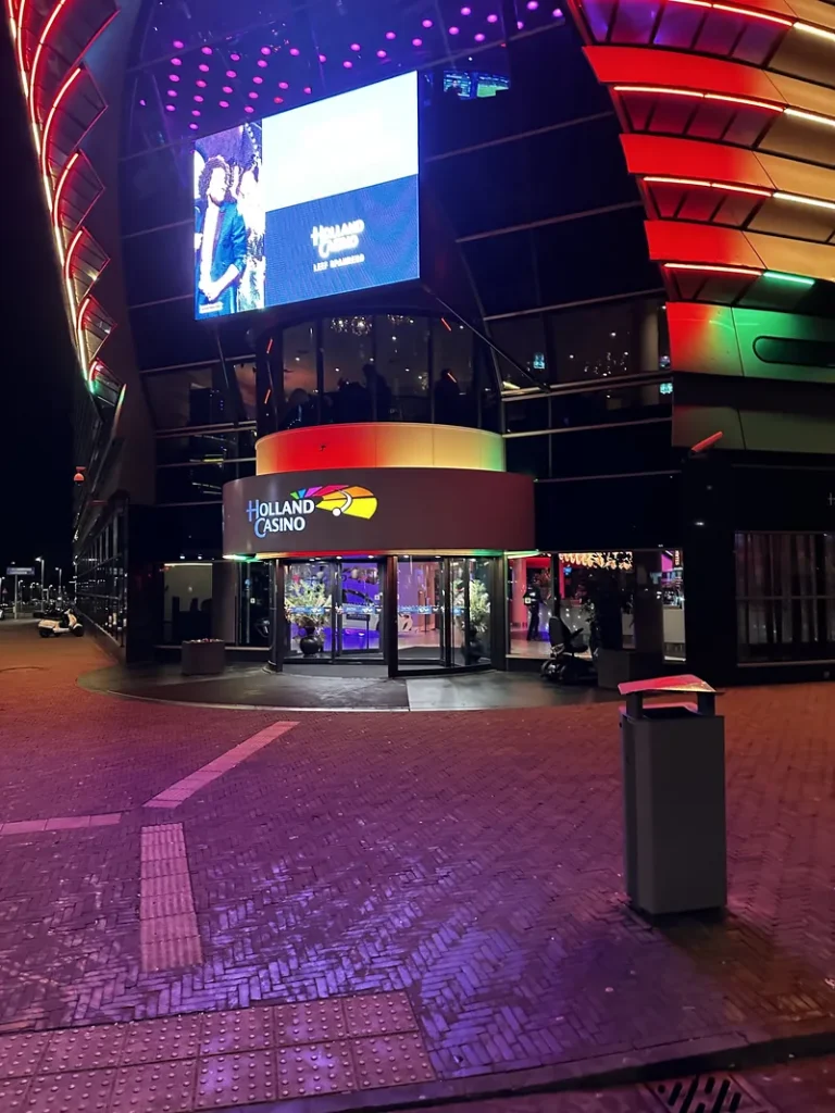 Verlichte ingang van Holland Casino Scheveningen bij nacht